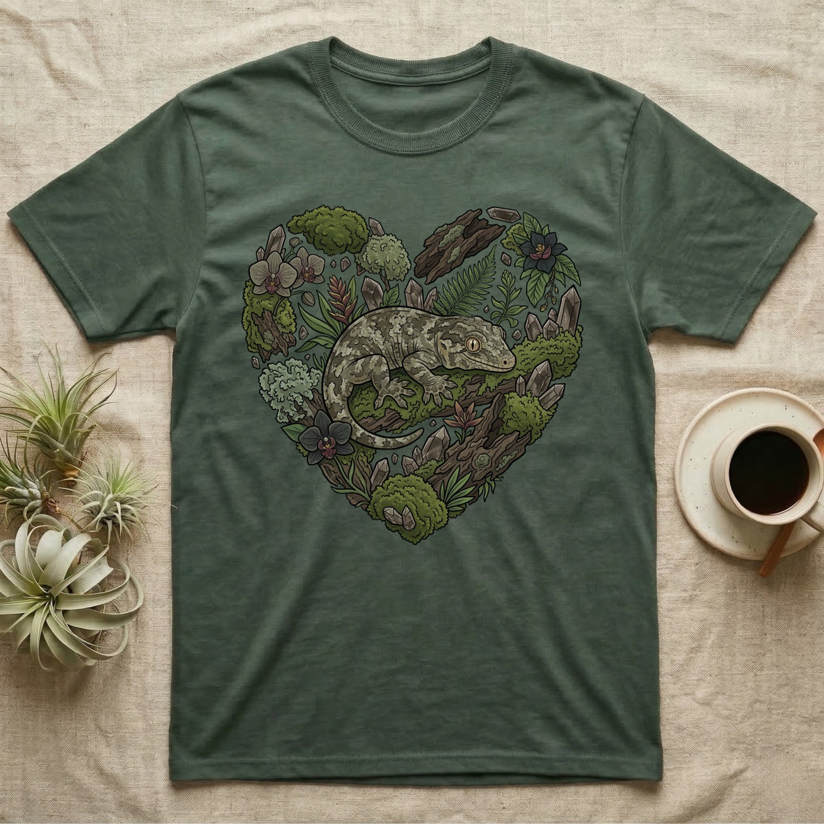 Green t-shirt with heart-shaped nature design featuring a gecko and plants.