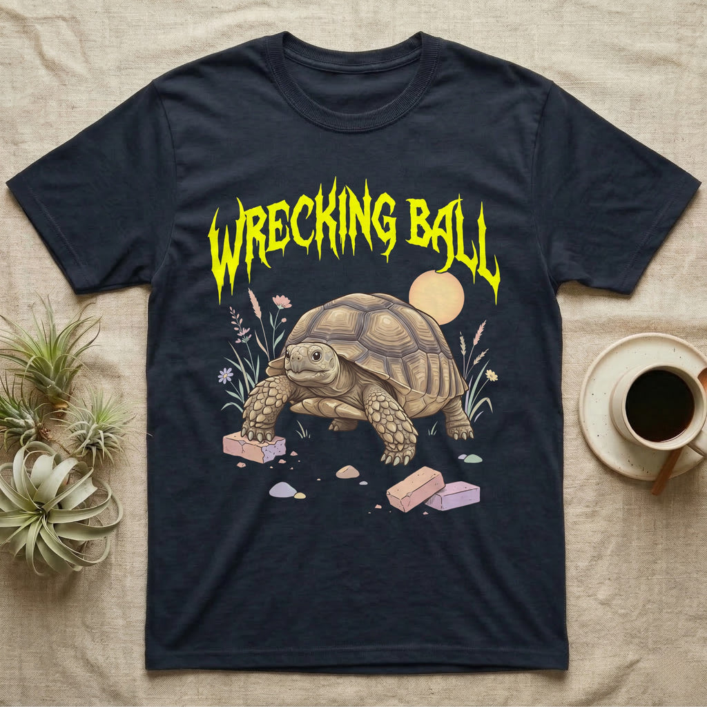 Sulcata Tortoise Feral T-Shirt in Navy — Sulcata tortoise plodding over crumbled bricks under a jagged caution-yellow metal "WRECKING BALL" wordmark.