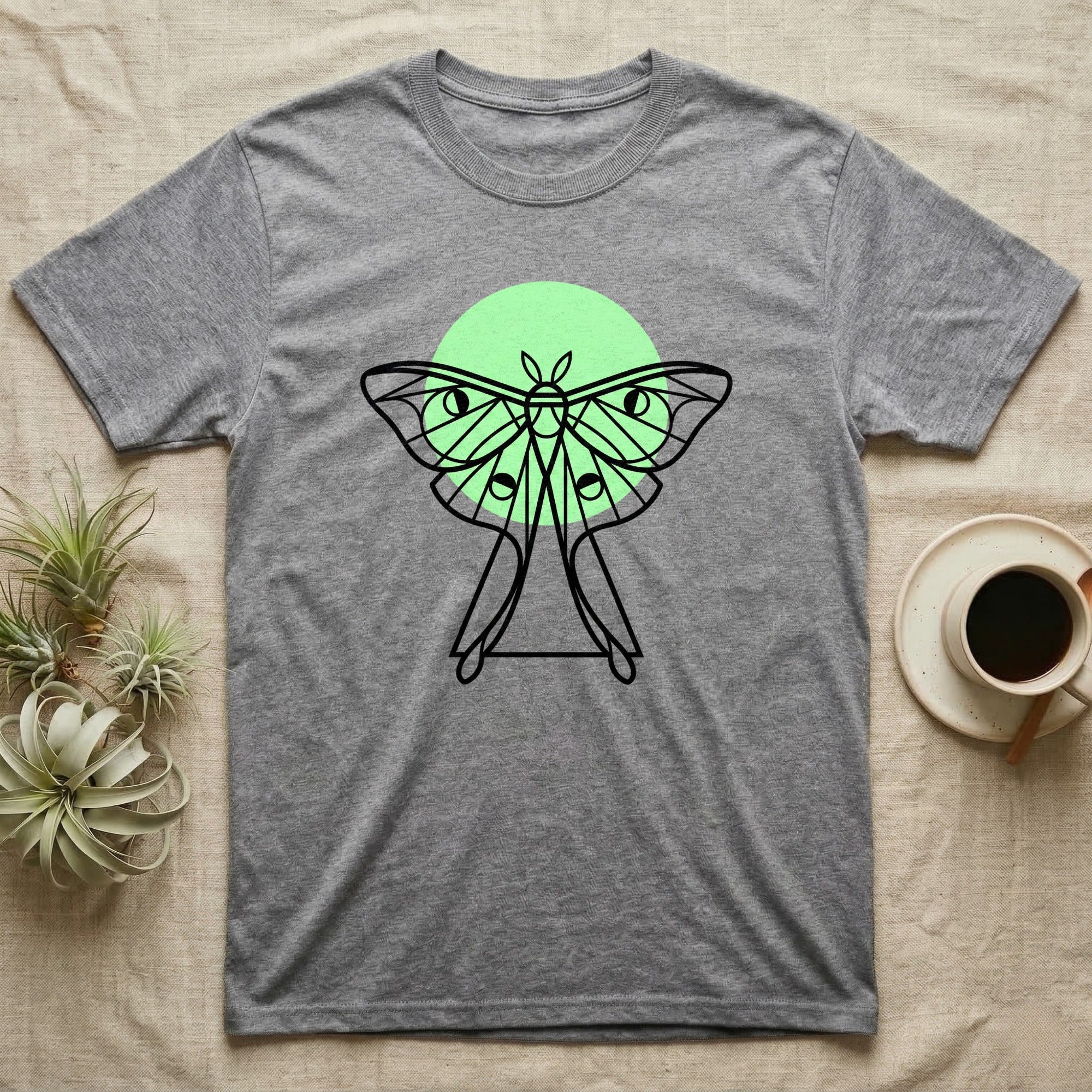 Grey t-shirt with a black line drawing of a luna moth and green circle.