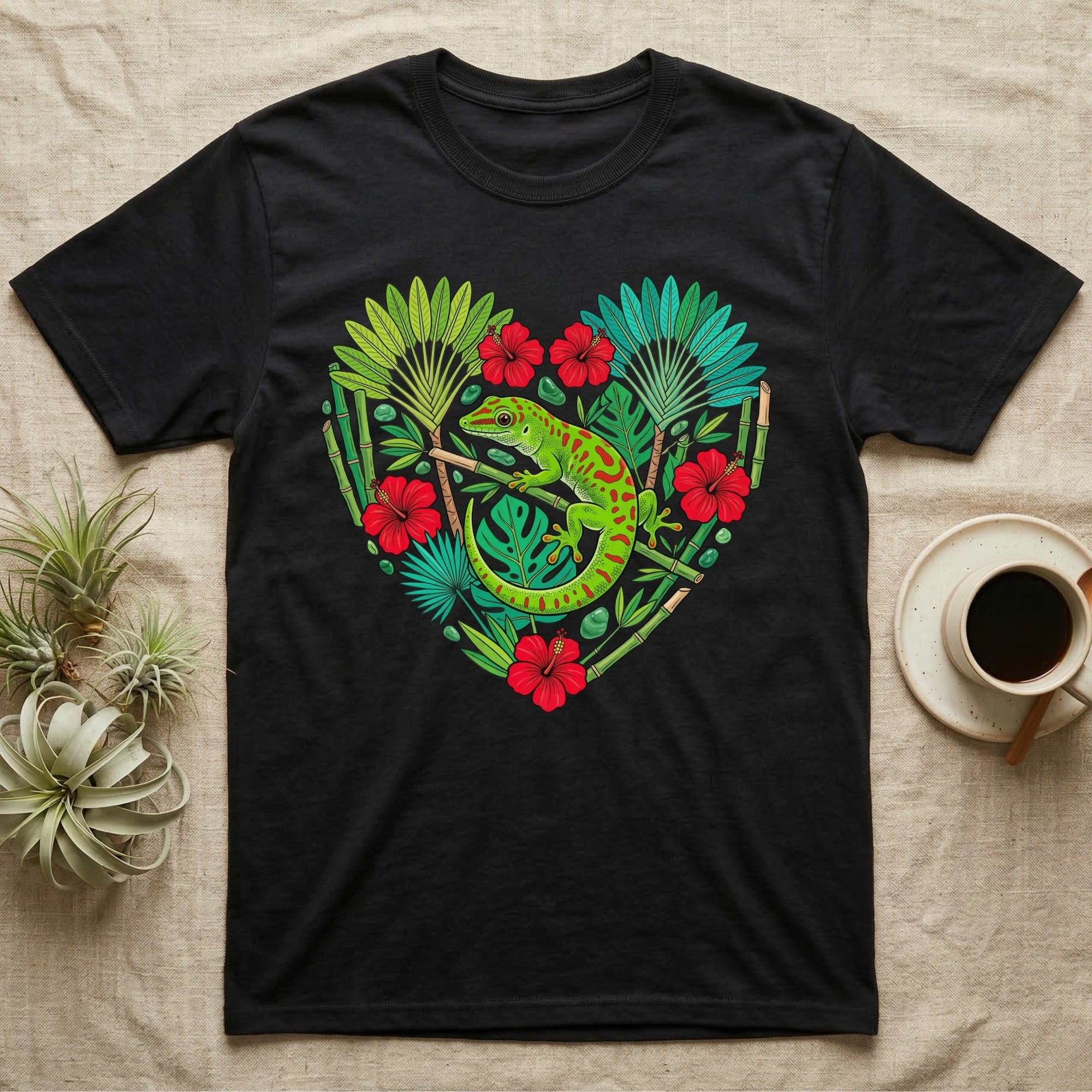 Black t-shirt with a green gecko and tropical plants forming a heart shape.