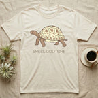 Light tan t-shirt with a tortoise graphic and "SHELL COUTURE" text.