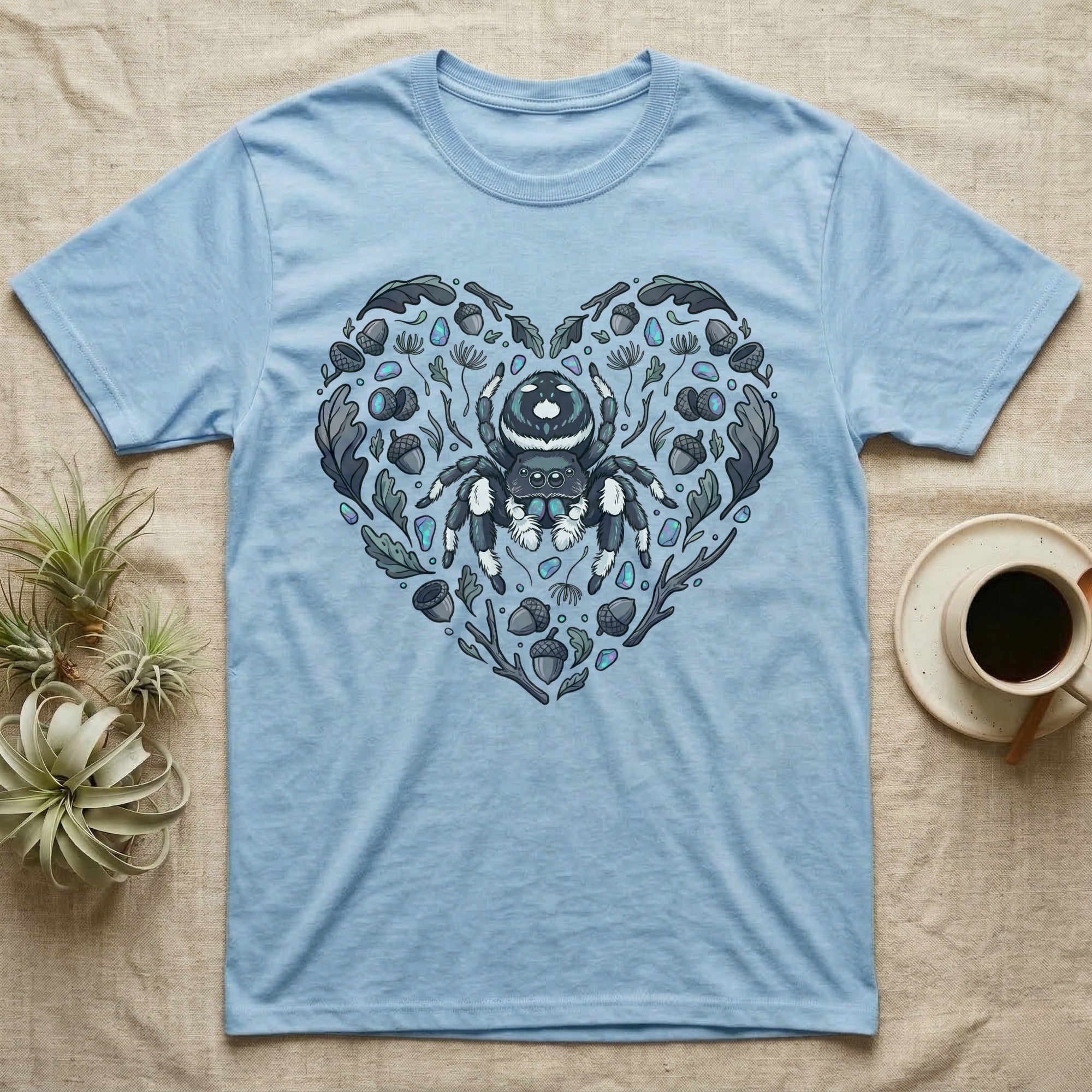 Light blue t-shirt with heart-shaped spider and nature graphic.