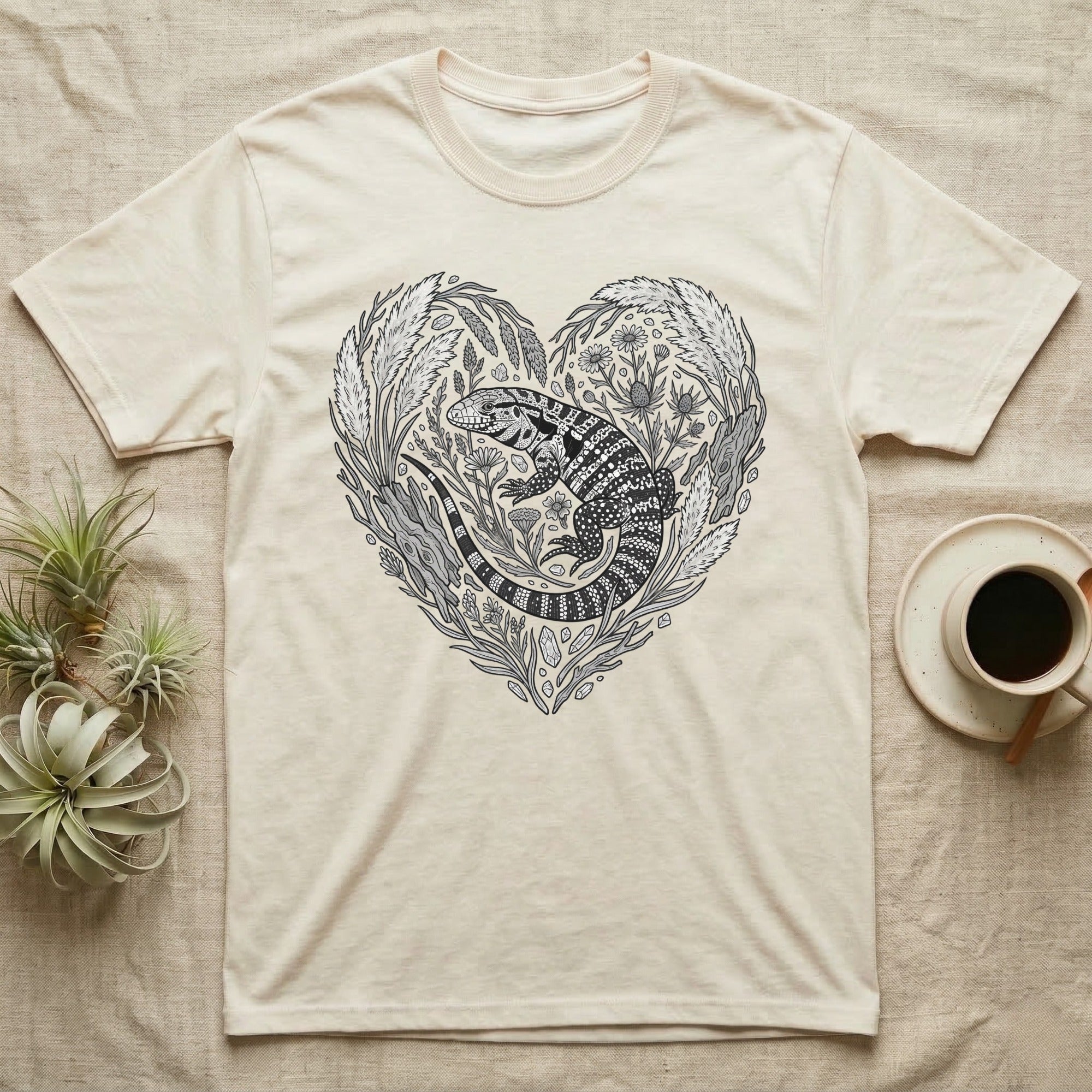 Cream t-shirt with heart-shaped botanical illustration of a lizard.