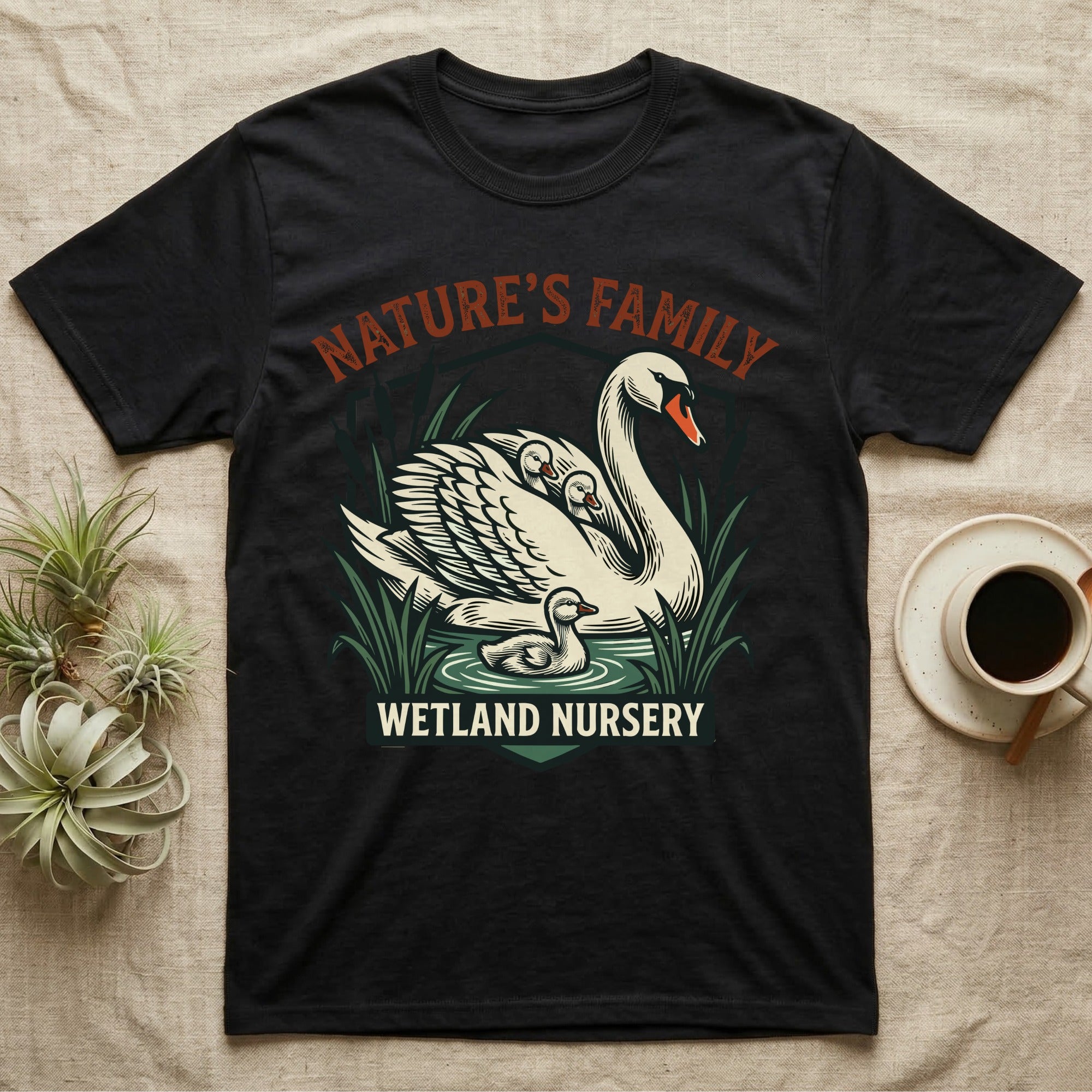 Black t-shirt with "Nature's Family Wetland Nursery" text and swan illustration.