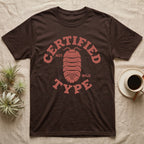 Isopod Certified Morph T-Shirt in Dark Chocolate — Carved block-print isopod seen from above inside a ring of terracotta lettering reading CERTIFIED NOT WILD TYPE.