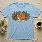 Blue t-shirt featuring a sleeping red fox surrounded by ferns and mushrooms.