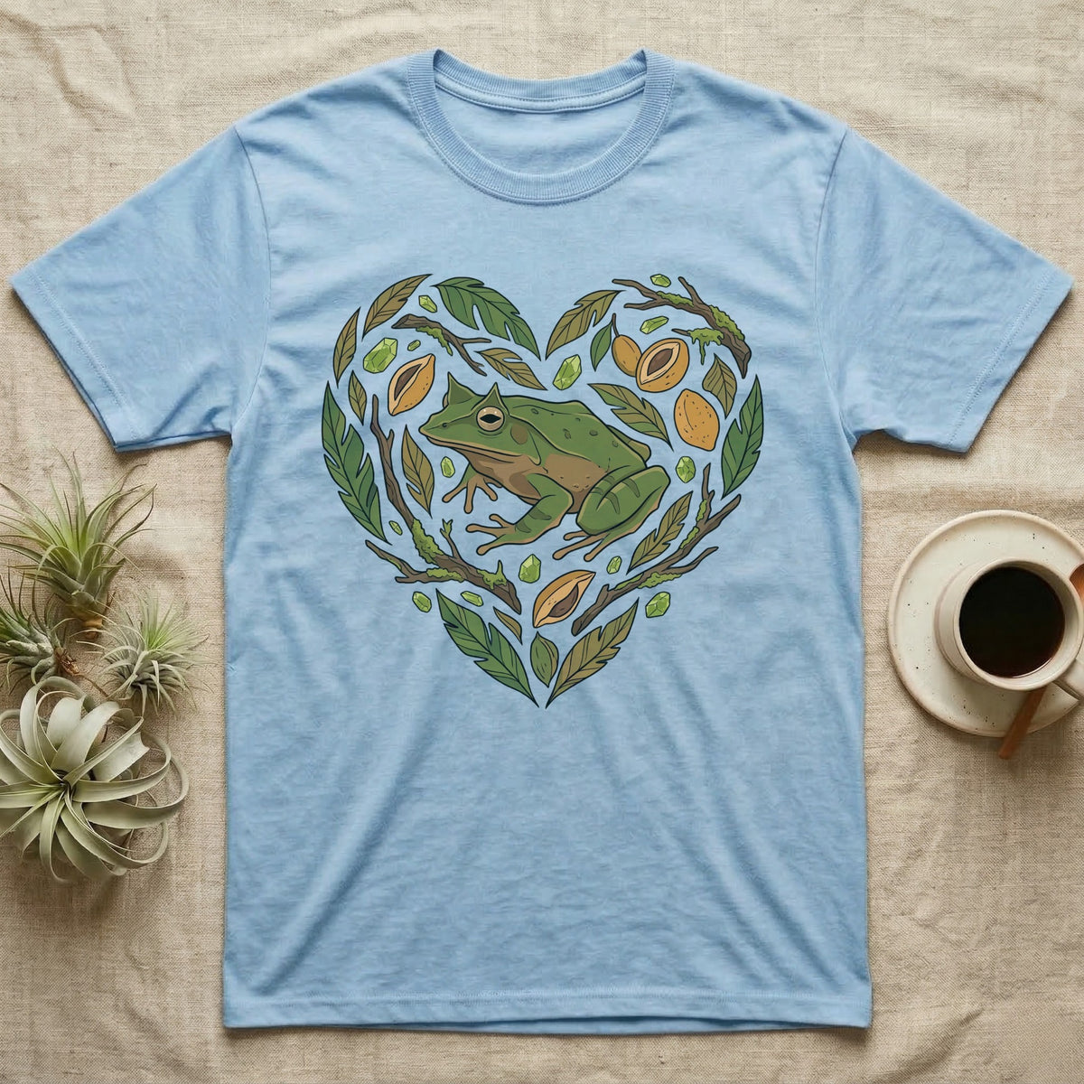 Light blue t-shirt with a green frog and heart-shaped nature design.