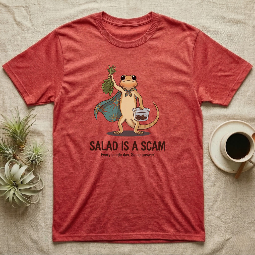 Bearded Dragon Salad Scam T-Shirt in Heather Red — Storybook-cartoon bearded dragon holding wilted greens at arm's length and a tub of roaches, captioned "Salad Is a Scam".