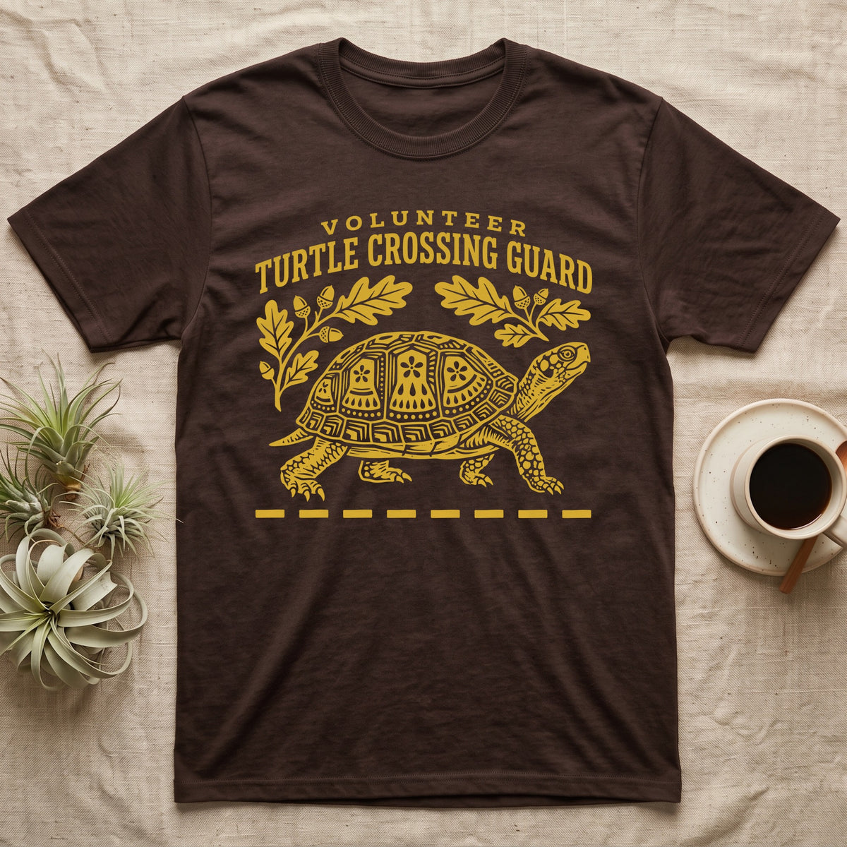 Box Turtle Crossing T-Shirt in Dark Chocolate — Yellow folk-print eastern box turtle walking across a dashed road line with oak leaves, text Volunteer Turtle Crossing Guard