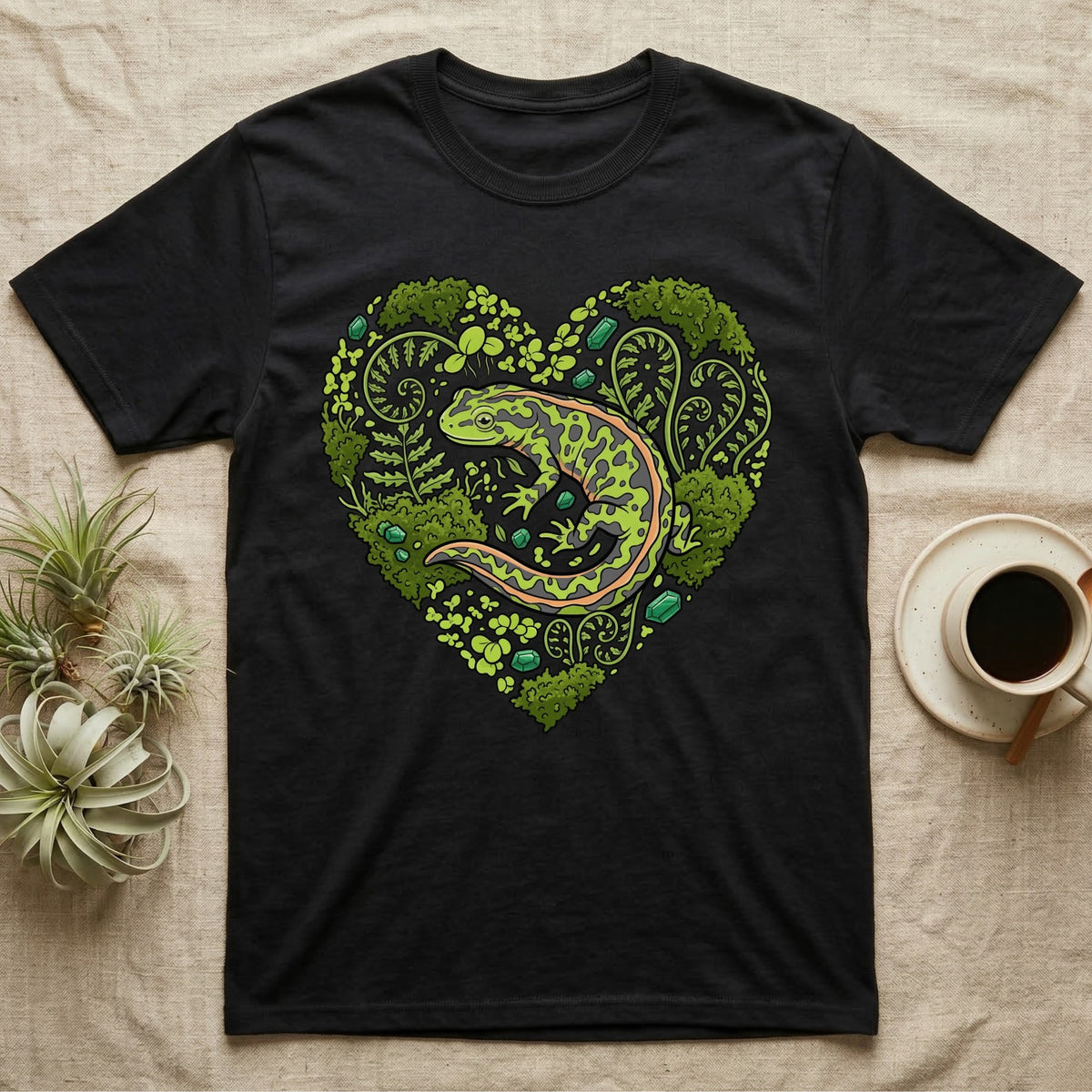 Black t-shirt featuring a green salamander within a heart-shaped forest design.