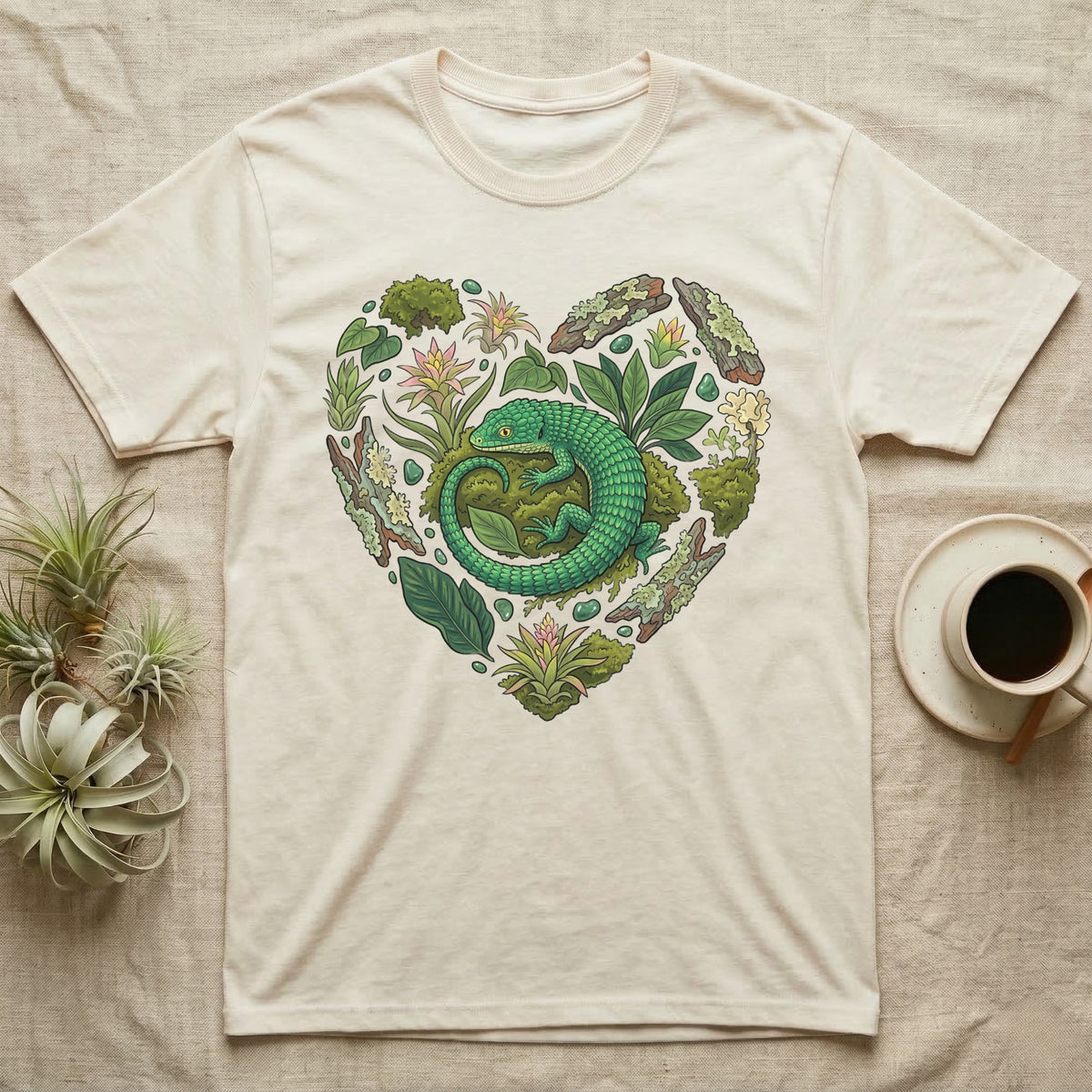 Heart-shaped design with green lizard and plants on a cream t-shirt.