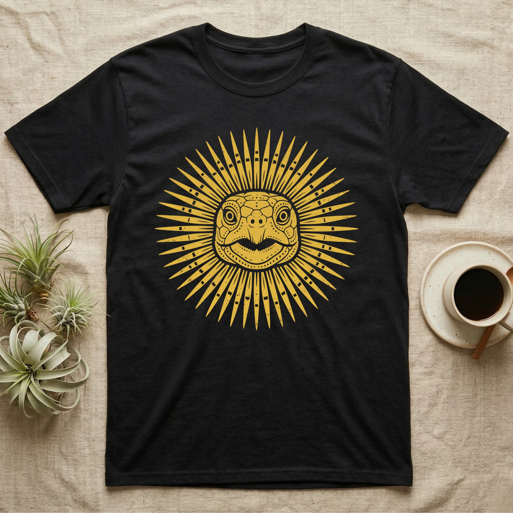 Hermann's Tortoise Sunburst T-Shirt in Black — Horn-yellow woodblock Hermann's tortoise seen head-on, its shell scutes radiating outward into a sunburst medallion.