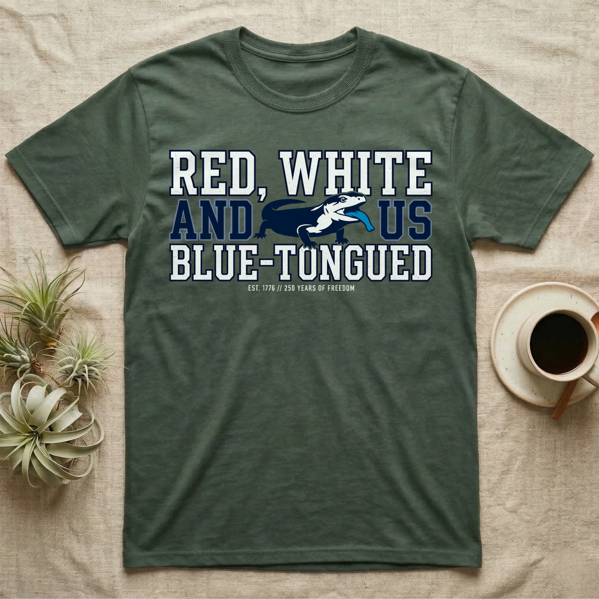Blue-Tongued Skink 1776 T-Shirt in Military Green — Navy and white blue-tongued skink with tongue out between collegiate text reading Red, White and US Blue-Tongued.