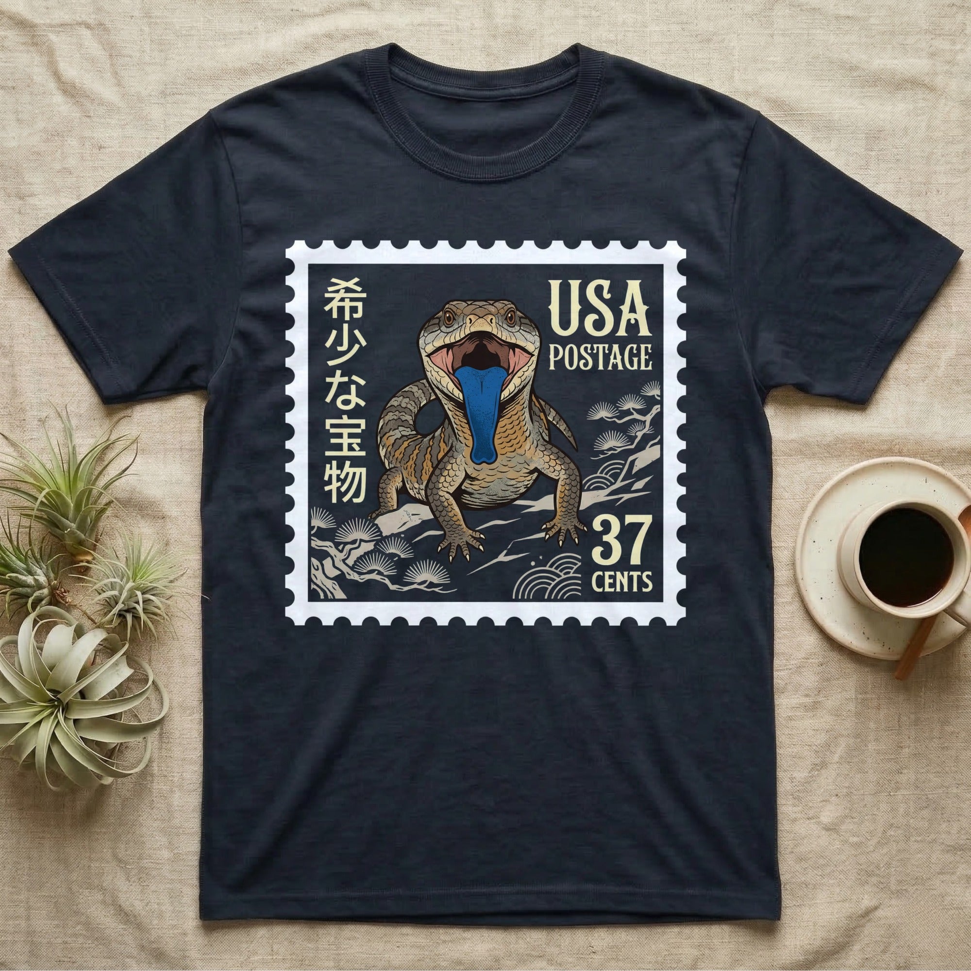 Dark t-shirt with a postage stamp design featuring a lizard and "USA Postage 37 Cents".