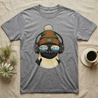 T-shirt with a graphic of a penguin wearing headphones and a beanie, reflecting mountains in sunglasses.