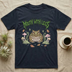 Pacman Frog Feral T-Shirt in Navy — Round Pacman frog in a pastel forest-floor scene under a spiky leaf-green metal wordmark reading MOUTH WITH LEGS.
