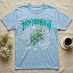 Veiled Chameleon Feral T-Shirt in Light Blue — Veiled chameleon on a branch with swivelling eyes under a jagged turquoise metal "DON'T PERCEIVE ME" wordmark.
