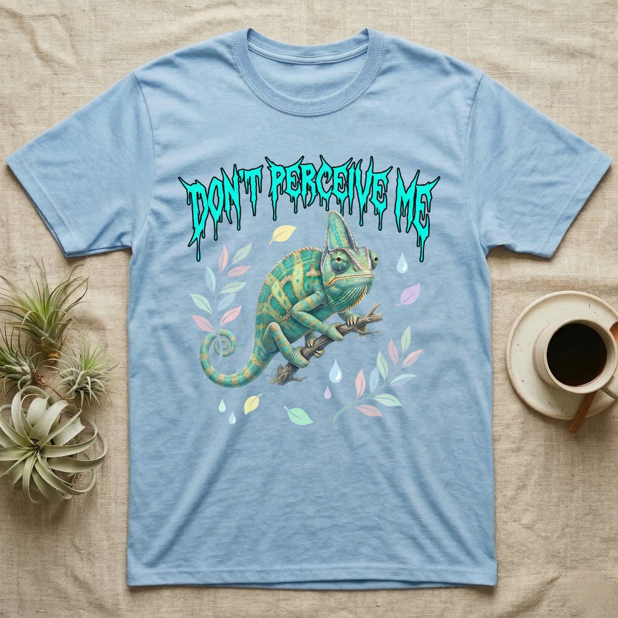 Veiled Chameleon Feral T-Shirt in Light Blue — Veiled chameleon on a branch with swivelling eyes under a jagged turquoise metal "DON'T PERCEIVE ME" wordmark.