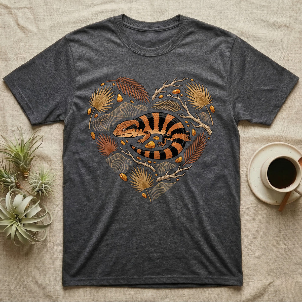 Dark grey t-shirt with a heart-shaped design featuring a striped lizard and foliage.
