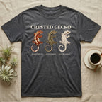 Crested Gecko Morph Chart T-Shirt in Dark Heather — Impasto painted chart of three crested gecko morphs — harlequin, pinstripe and dalmatian — labelled beneath each gecko.