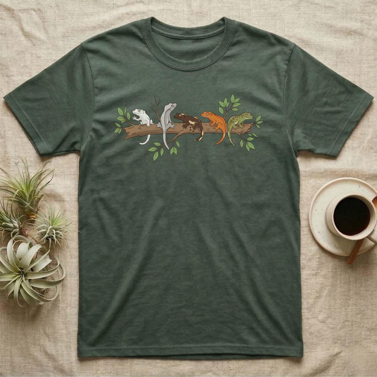 Crested Gecko Morph Line T-Shirt in Military Green — Five crested gecko morphs in ink and watercolour perched along one cork bark branch with ficus leaves.