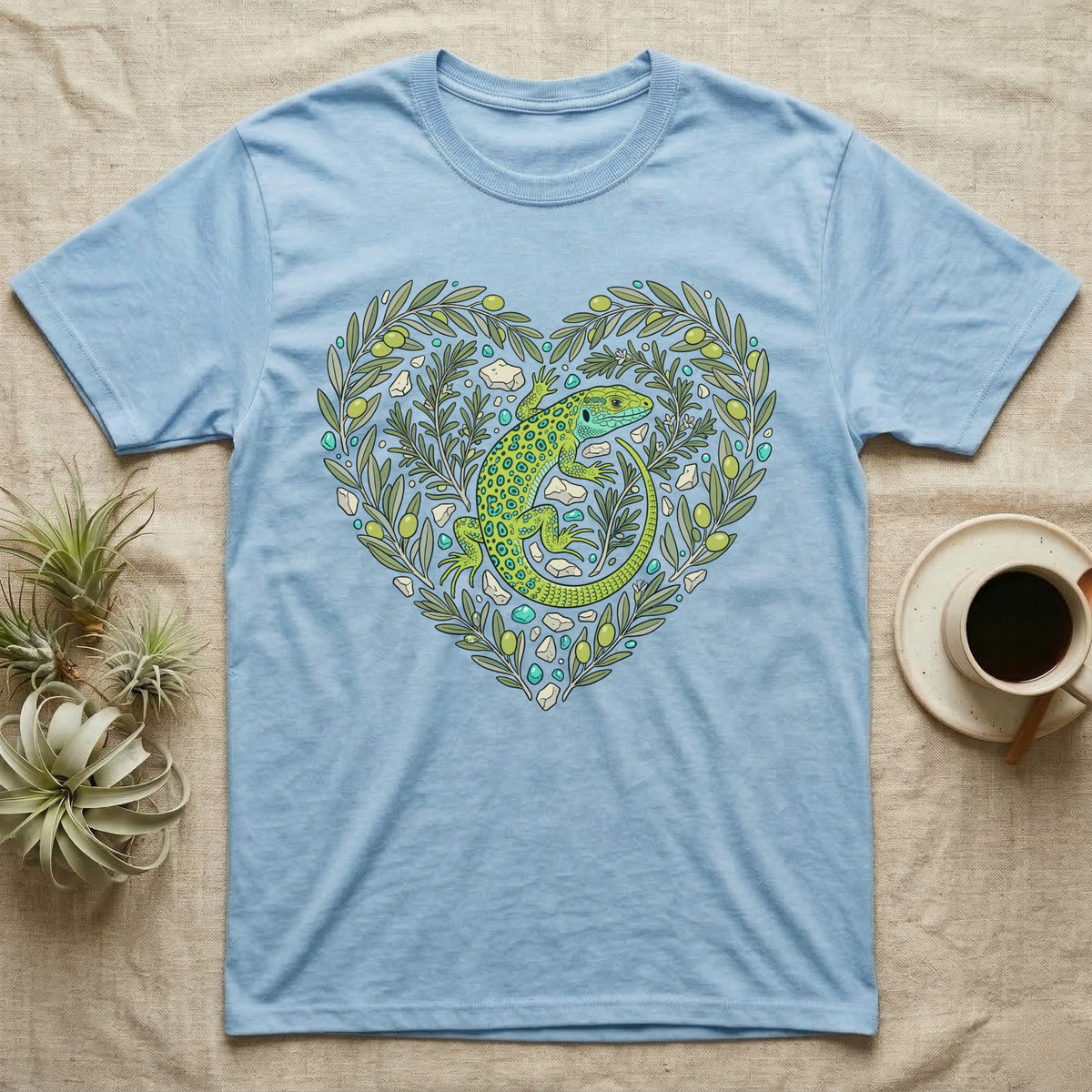 Light blue t-shirt with green lizard and olive branches forming a heart.