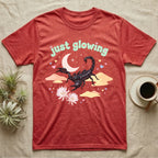 Emperor Scorpion Baby T-Shirt in Heather Red — Black emperor scorpion, pincers raised, under a pastel moon and stars with puffy mint bubble text "just glowing".