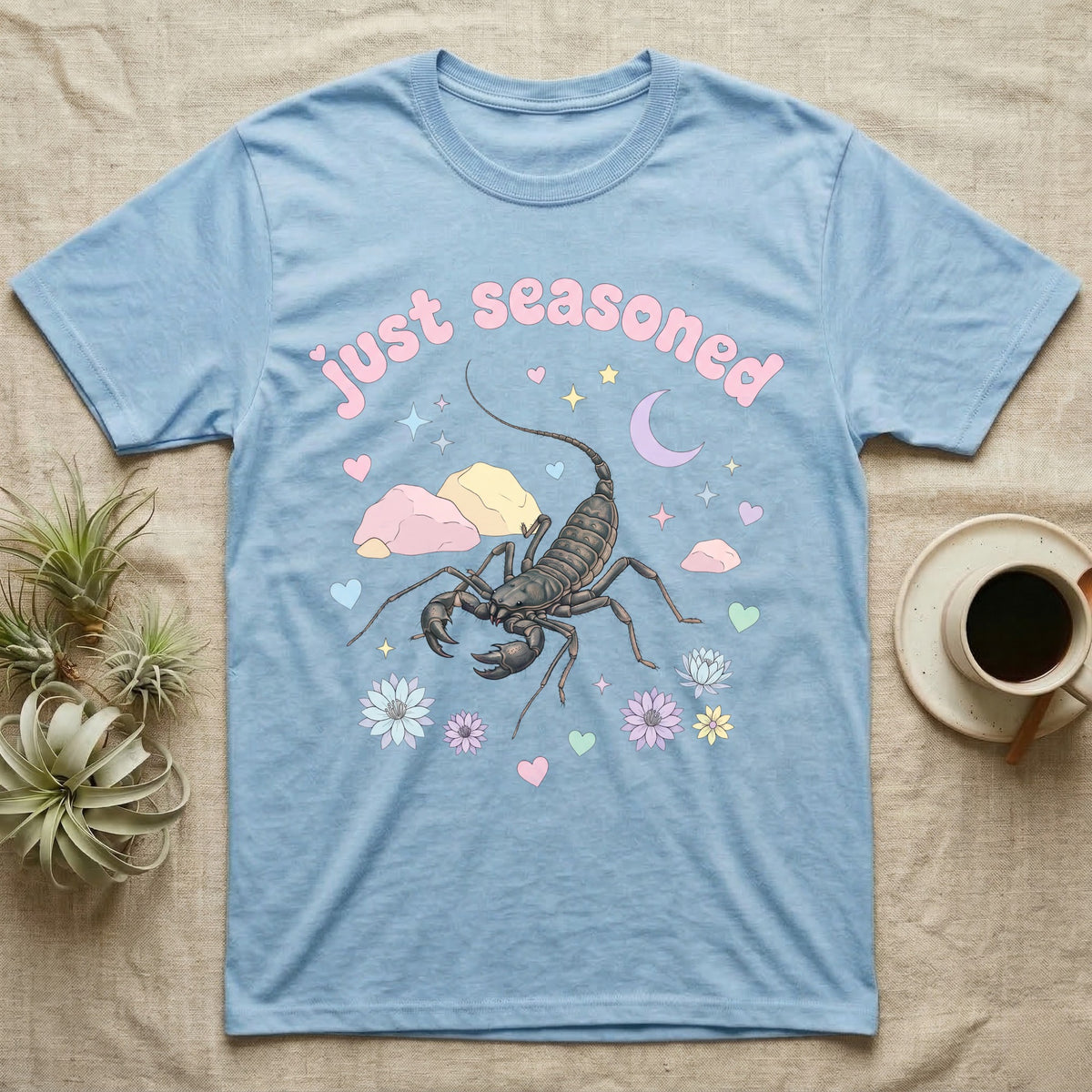 Giant Vinegaroon Baby T-Shirt in Light Blue — Pastel giant vinegaroon with pincers and whip tail among rocks and a crescent moon, puffy pink wordmark "just seasoned" above.