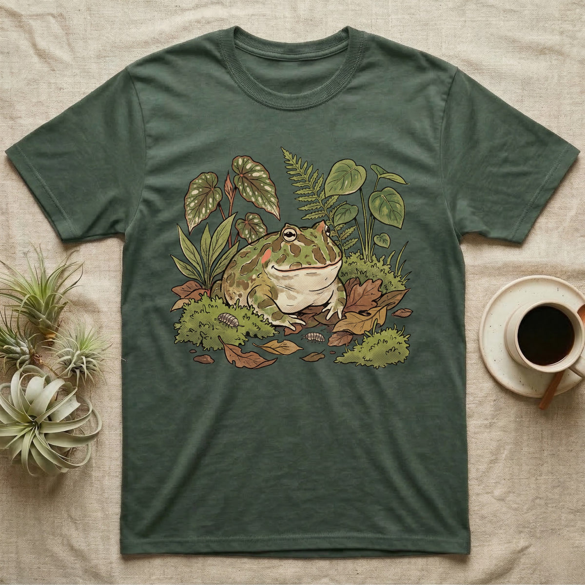 Bioactive Pacman Frog T-Shirt in Military Green — Warm botanical illustration of a content pacman frog half-buried in a lush bioactive habitat of moss and leaf litter.