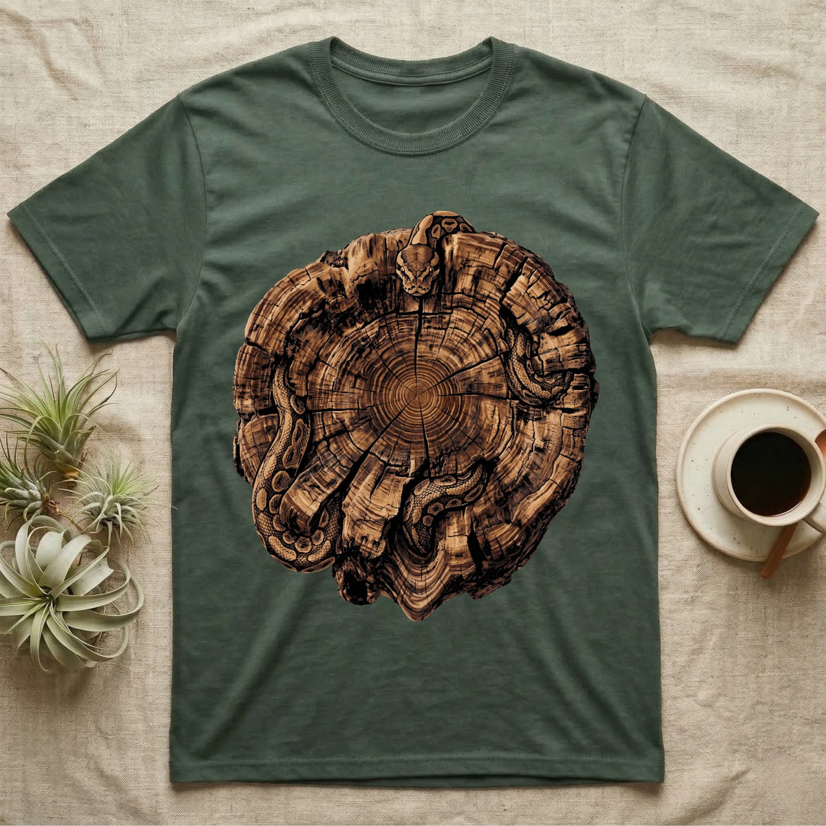 Ball Python Stump Coil T-Shirt in Military Green — Pyrography-style illustration of a ball python threaded through the charred radial cracks of a cross-section log, no on-shirt text.