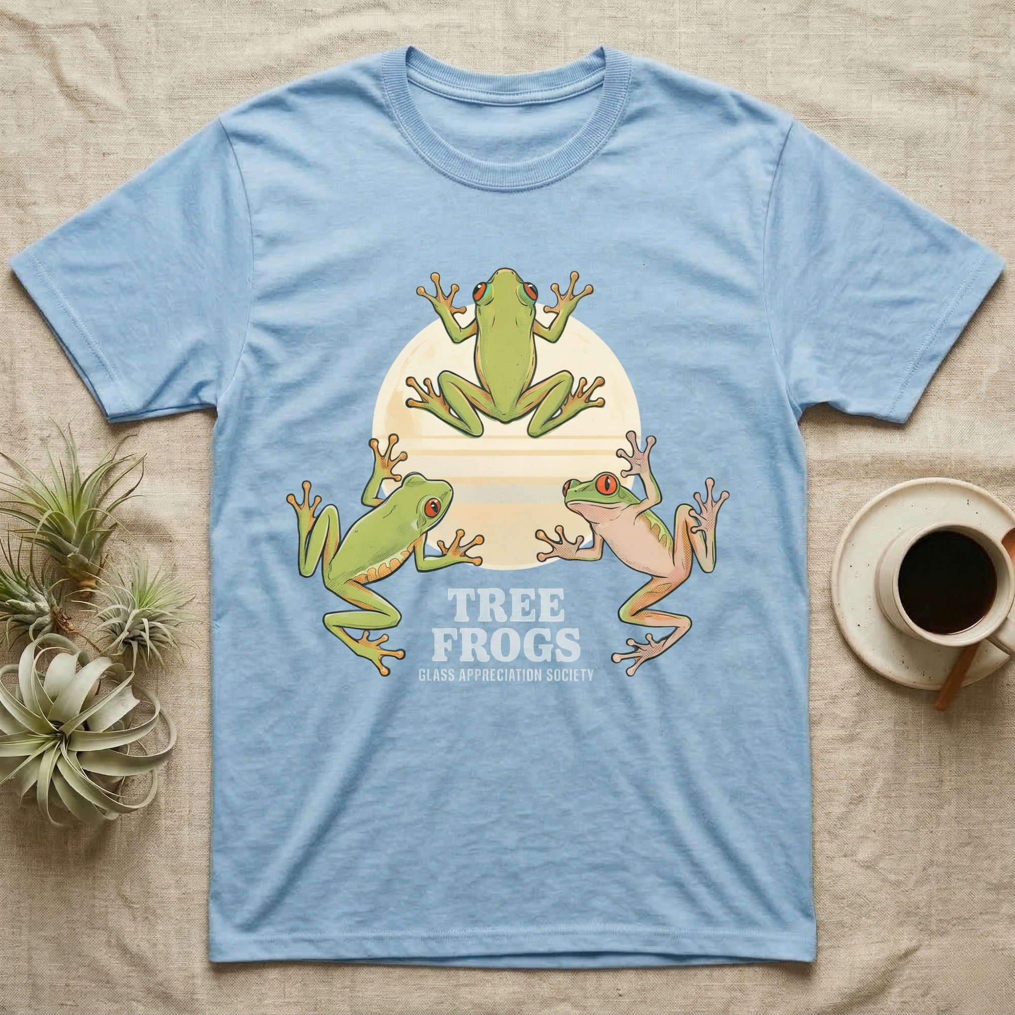 Three Tree Frog Moon T-Shirt in Light Blue — Retro-illustration of three tree frogs in splayed glass-cling poses around a stratified halftone full moon.