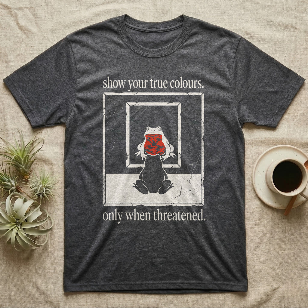 Fire-Bellied Toad Mirror T-Shirt in Dark Heather — Worn photocopy-style poster of a fire-bellied toad seen from behind looking into a mirror, its reflection showing a bright red marbled belly, with the words show your true colours, only when threatened.