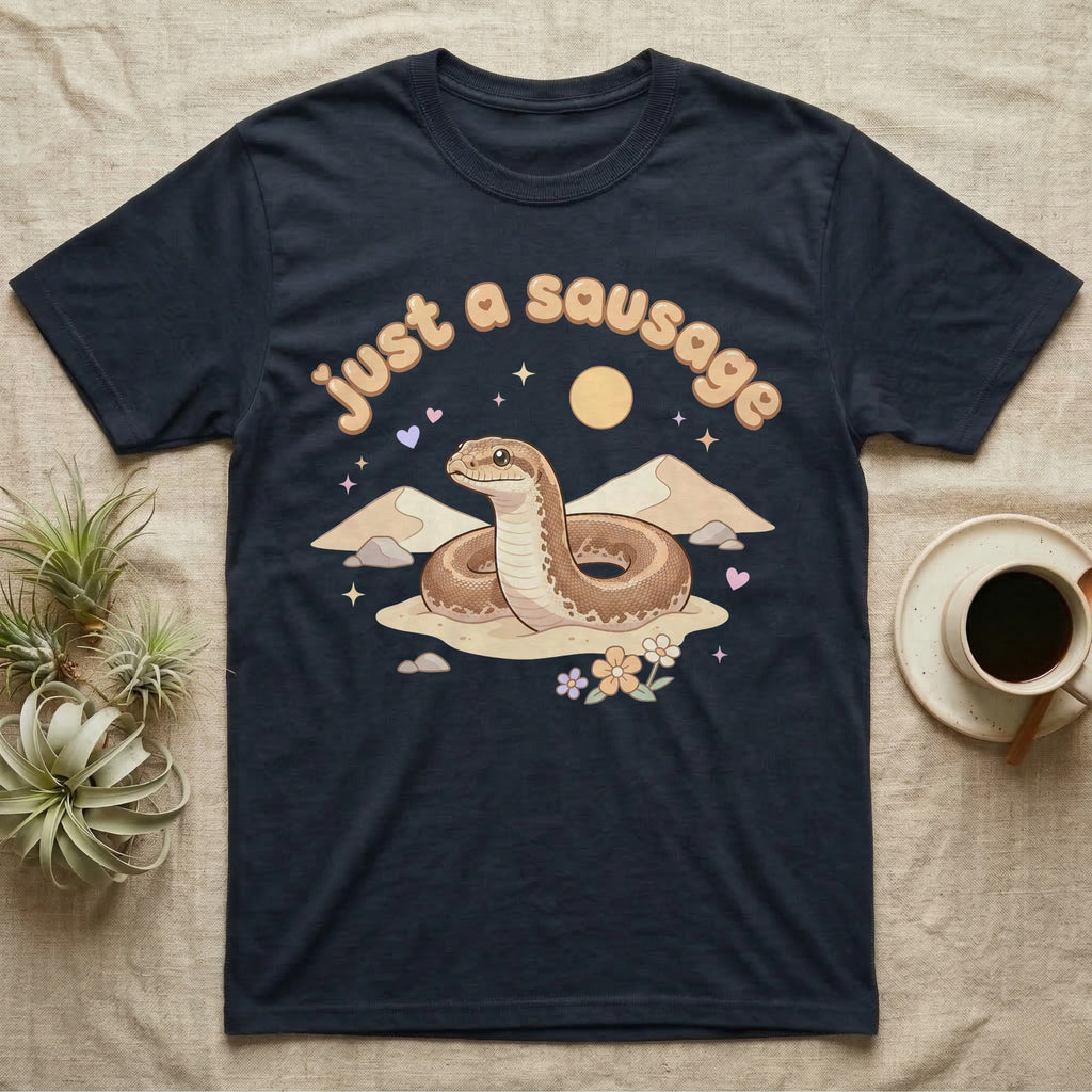 Kenyan Sand Boa Softie T-Shirt in Navy — Kenyan sand boa looping out of pastel sand dunes under a puffy "just a sausage" bubble wordmark with tiny hearts.