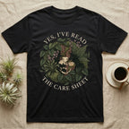 Crested Gecko Care Sheet T-Shirt in Black — Botanical wreath of pothos and moss circling a crested gecko, closed by two arcs of Roman capitals.