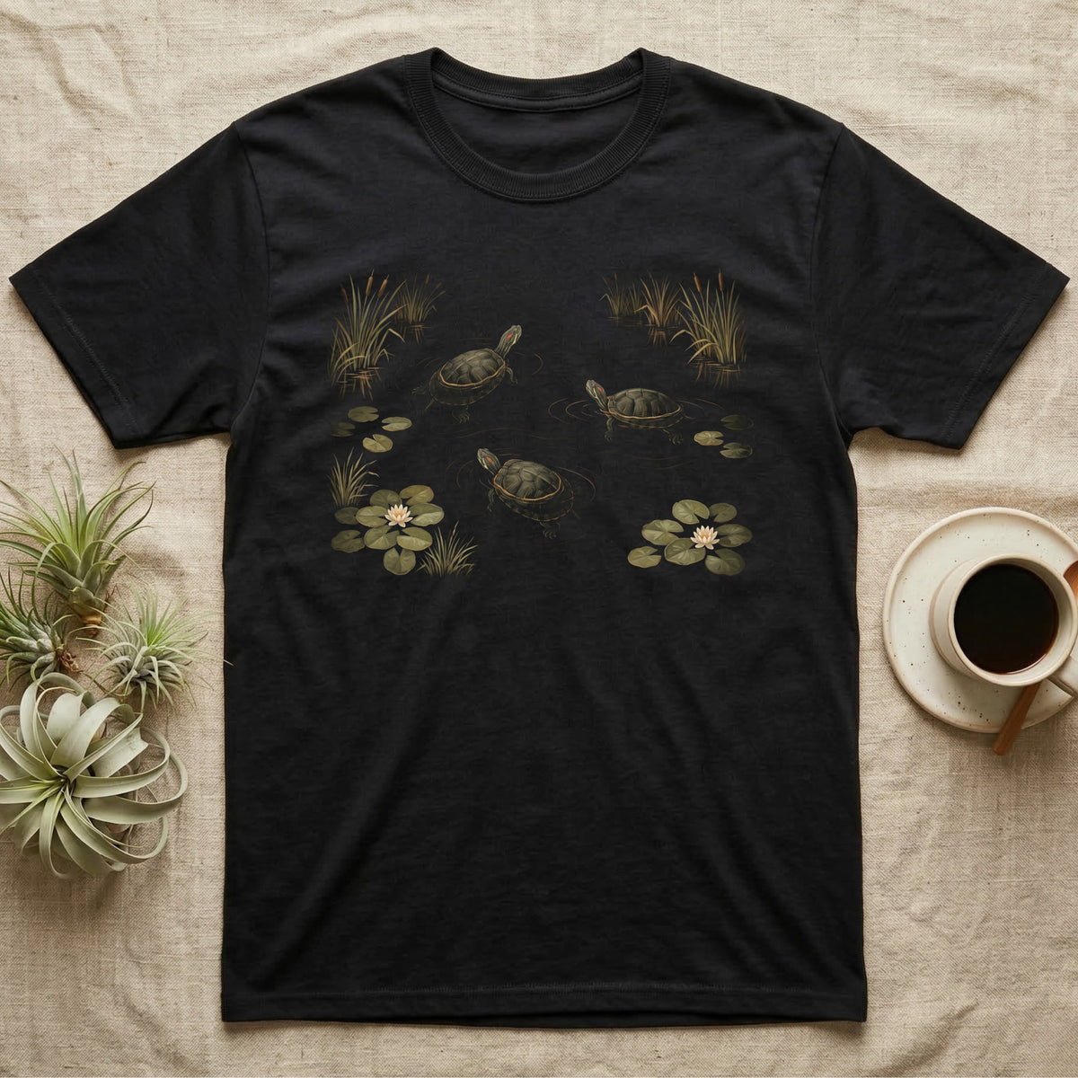 Red-Eared Slider Pond T-Shirt in Black — Painted 90s wildlife art of three red-eared sliders swimming a dark pond with golden ripples, water-lilies and cattails