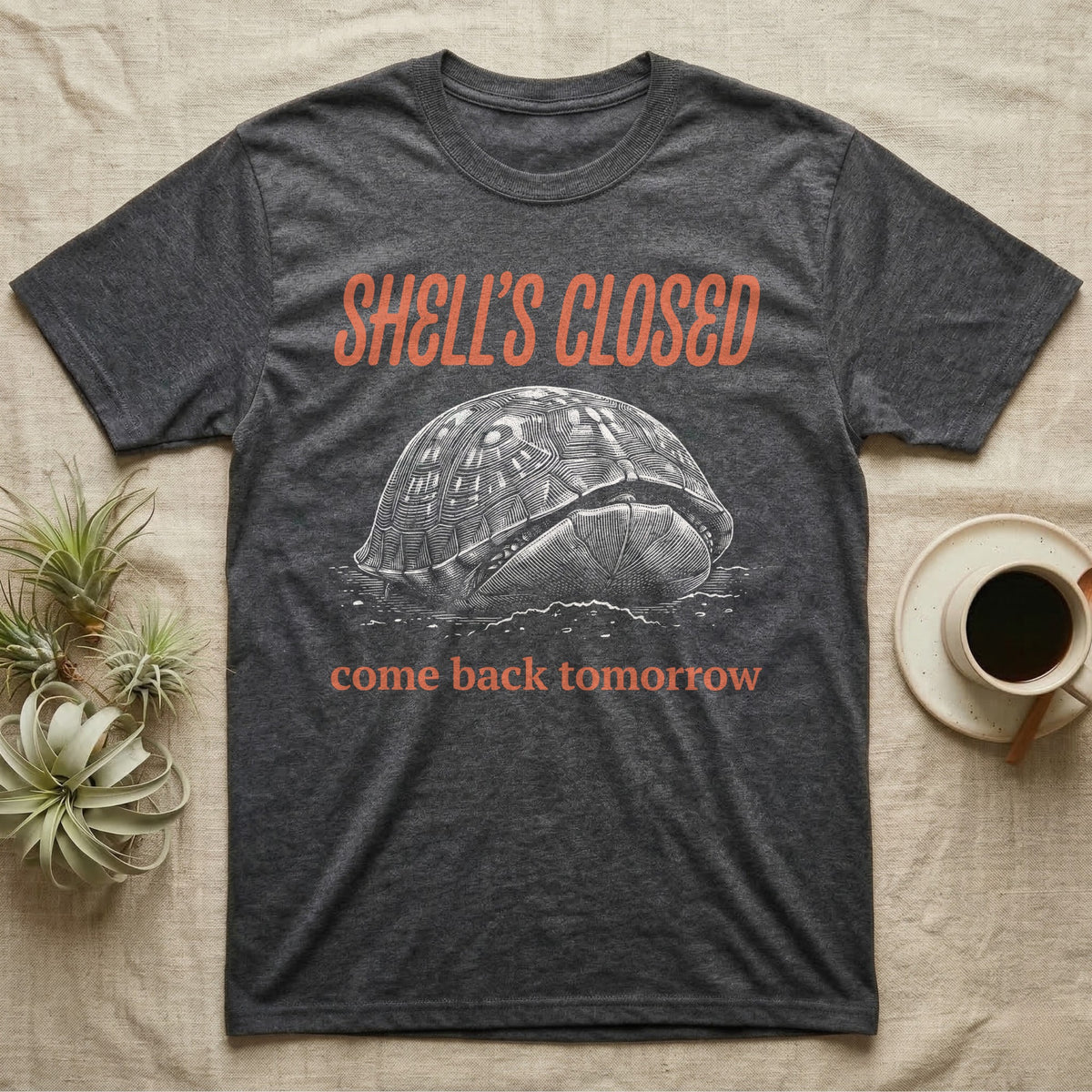 Box Turtle Shell's Closed T-Shirt in Dark Heather — Engraved white-line eastern box turtle shut tight under retro orange script reading SHELL'S CLOSED, come back tomorrow.