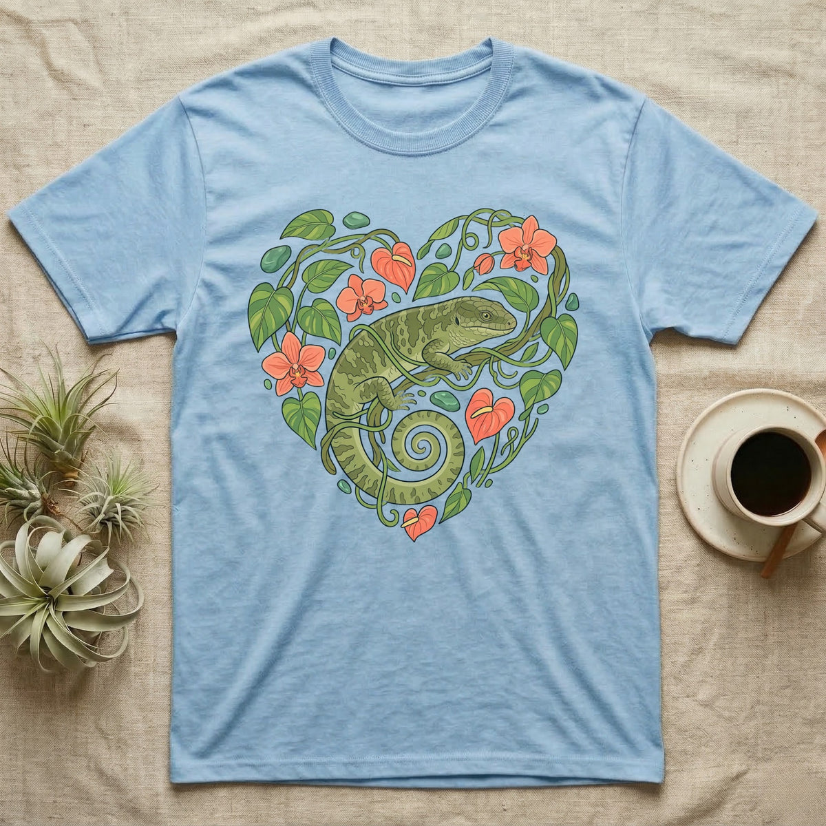 Light blue t-shirt with a green lizard in a heart-shaped floral design.
