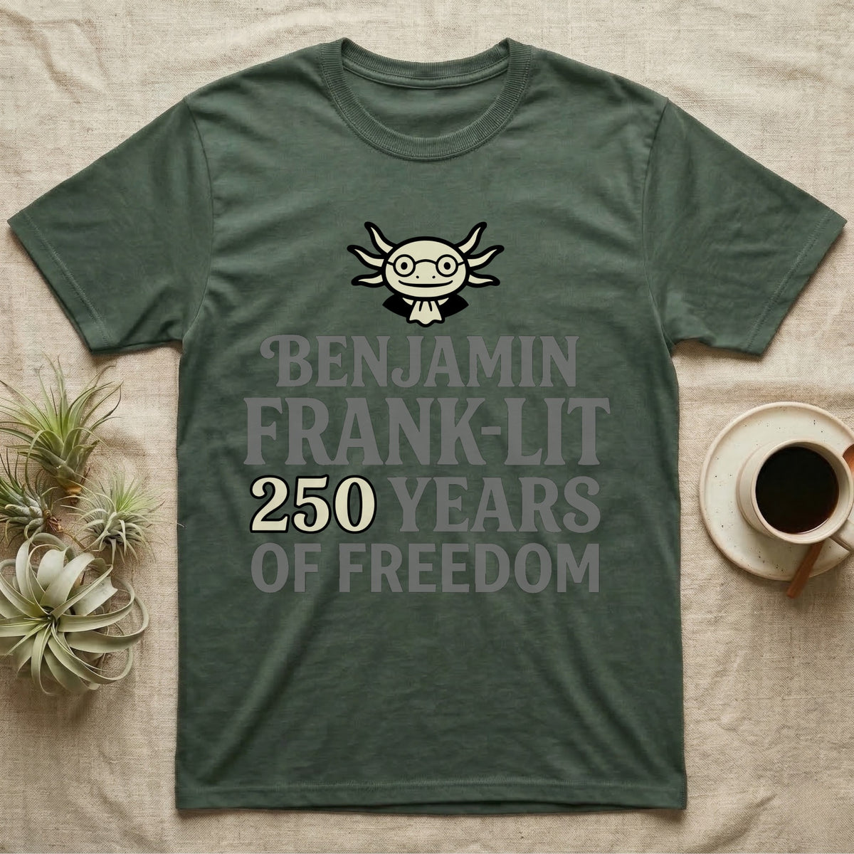 Axolotl Benjamin Franklin T-Shirt in Military Green — Flat cream axolotl as Ben Franklin in glasses above bold text reading Benjamin Frank-Lit, 250 Years of Freedom.