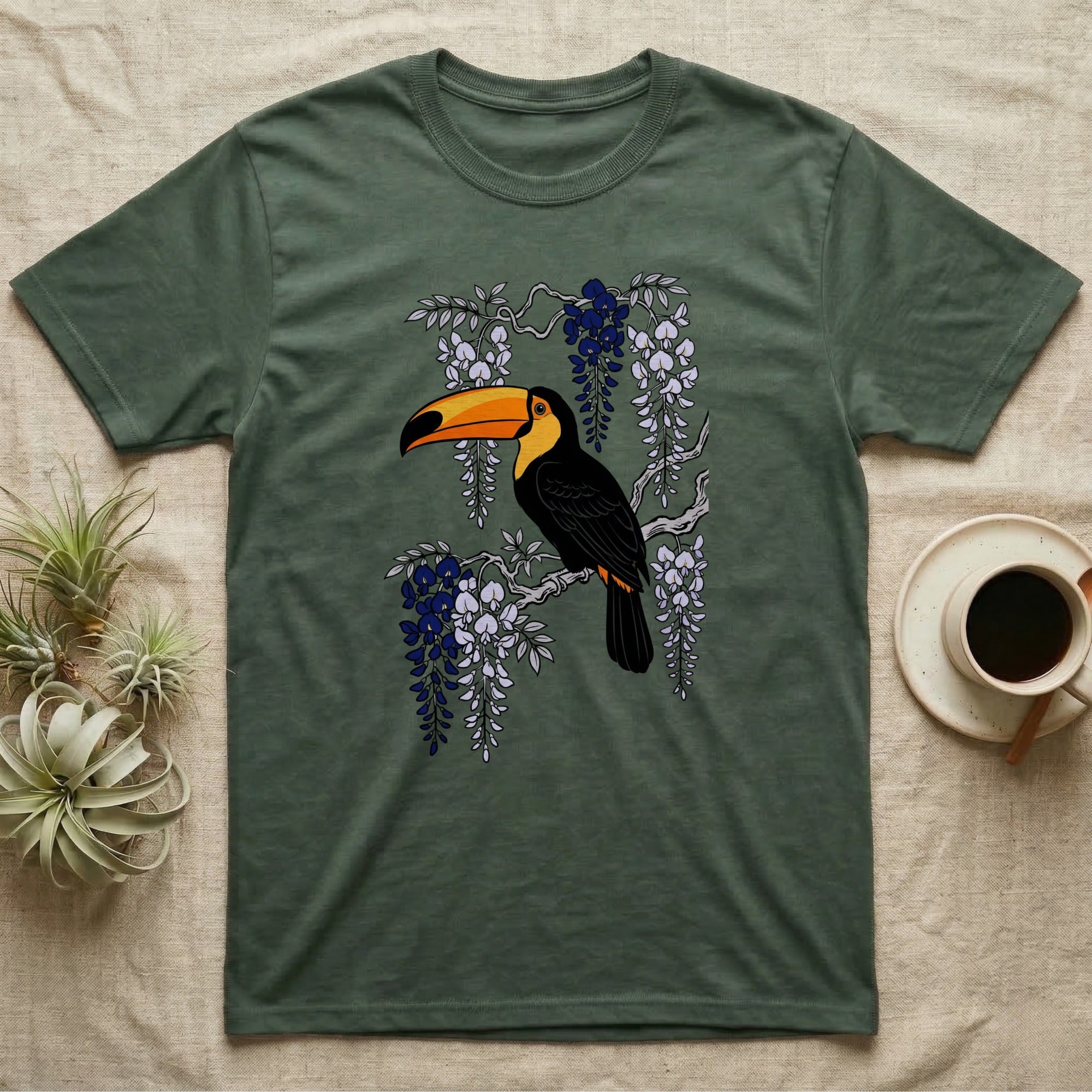 Green t-shirt with a toucan on a branch with purple wisteria.