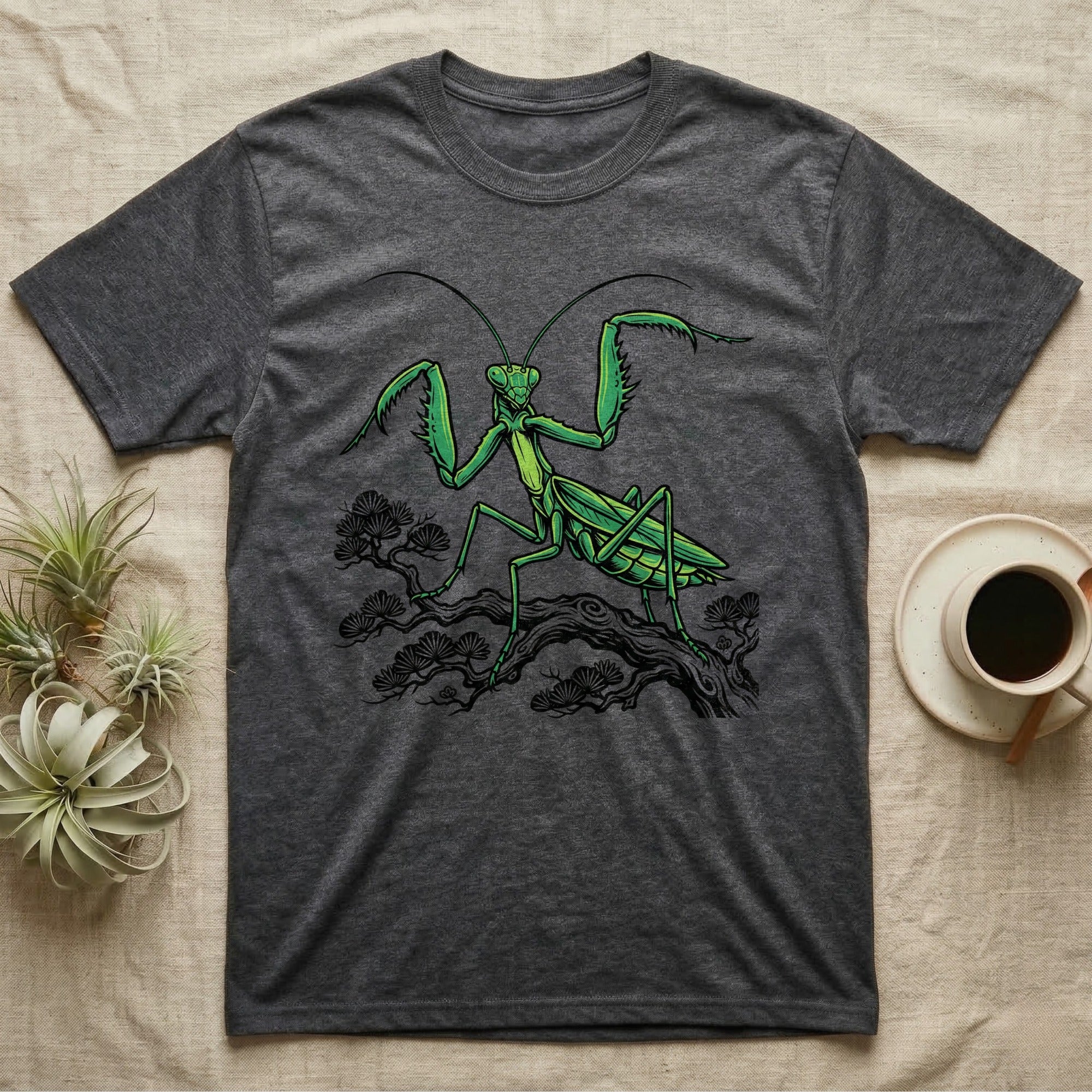 Dark grey t-shirt featuring a green praying mantis illustration on a tree branch.