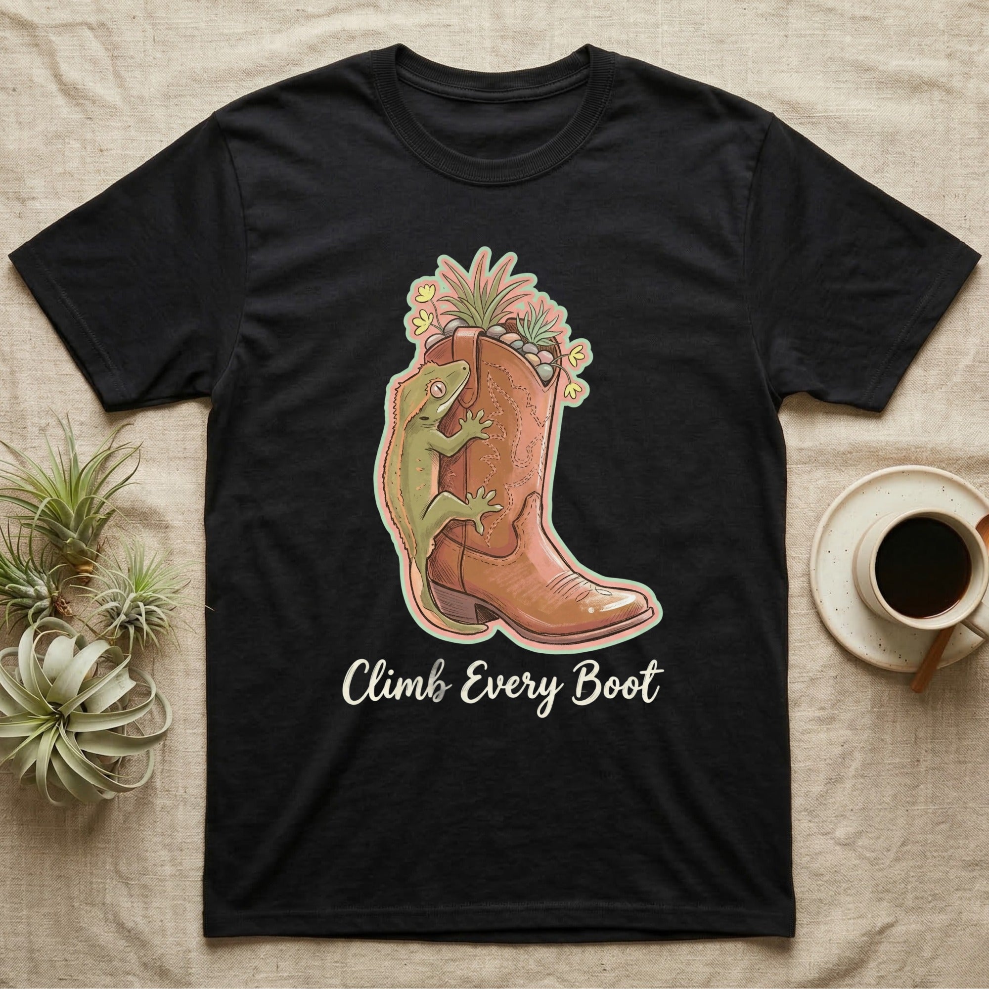 Black t-shirt with cowboy boot graphic, lizard, plants, and text "Climb Every Boot".