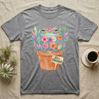 Tree Frog Thriving T-Shirt in Sport Grey — A White's tree frog made of watercolour flowers, sitting in a terracotta pot with a plant label reading STILL THRIVING.