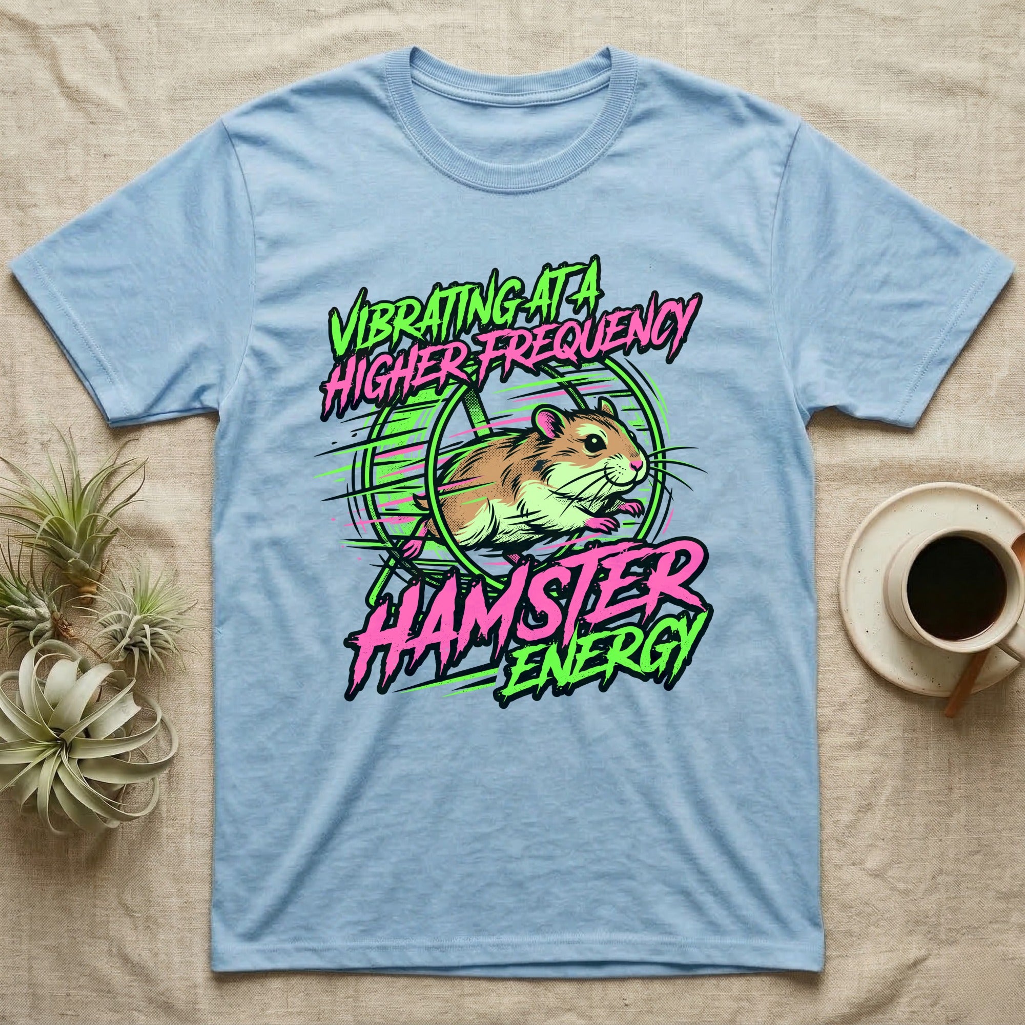 Light blue t-shirt with a vibrant graphic of a hamster and text "VIBRATING AT A HIGHER HAMSTER ENERGY".