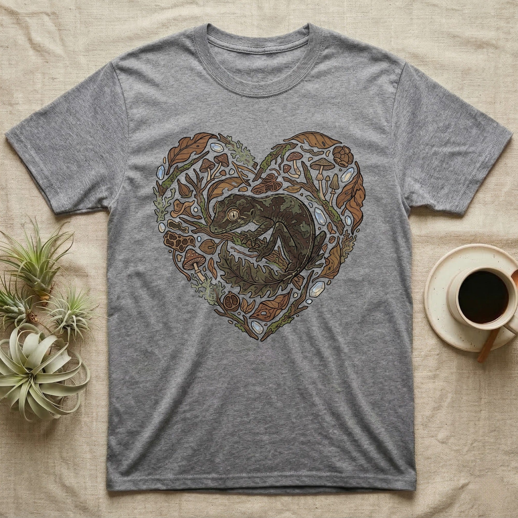 Grey t-shirt with heart-shaped naturalistic illustration of a gecko and leaves.
