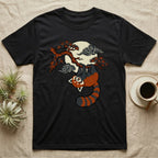 Black t-shirt with a red panda hanging from a tree branch under a cloudy moon.