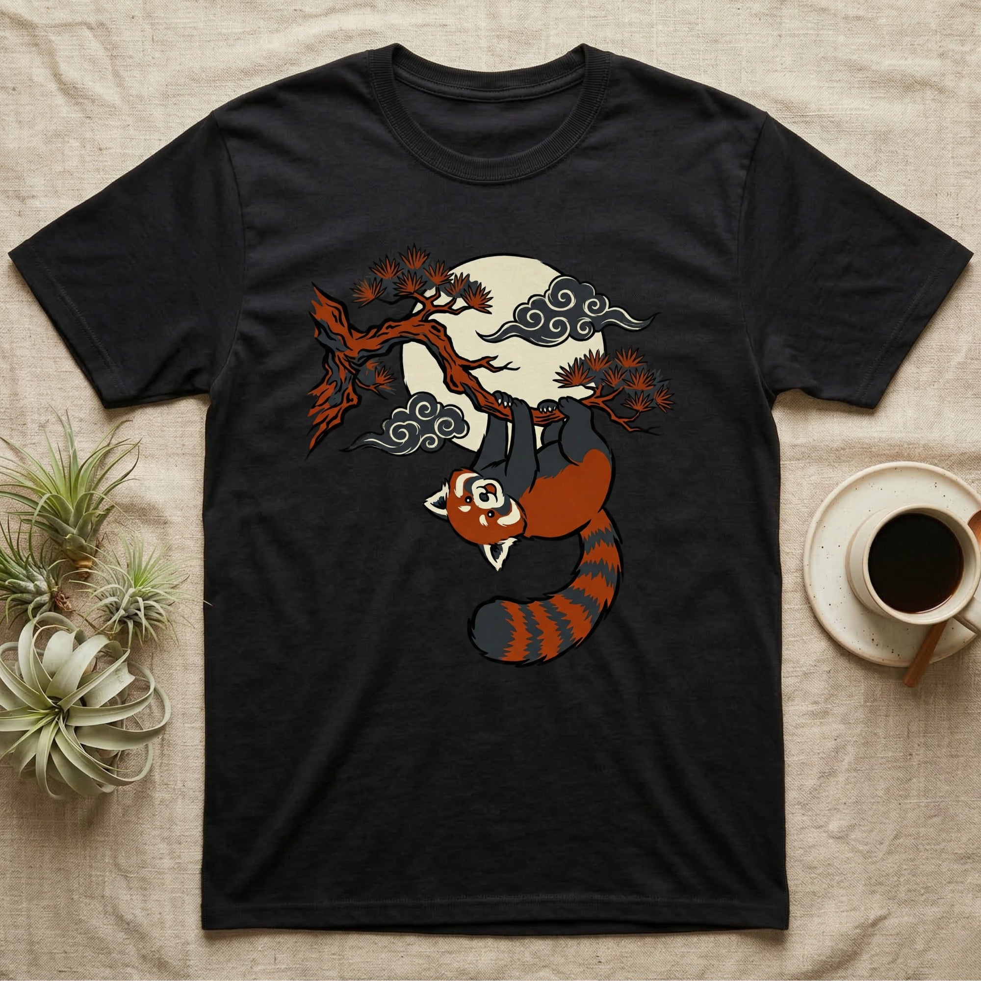 Black t-shirt with a red panda hanging from a tree branch under a cloudy moon.