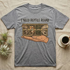 Crested Gecko Rehab T-Shirt in Sport Grey — Vector scene of a hand presenting a rack of four crested geckos under a marker-style reptile rehab caption.