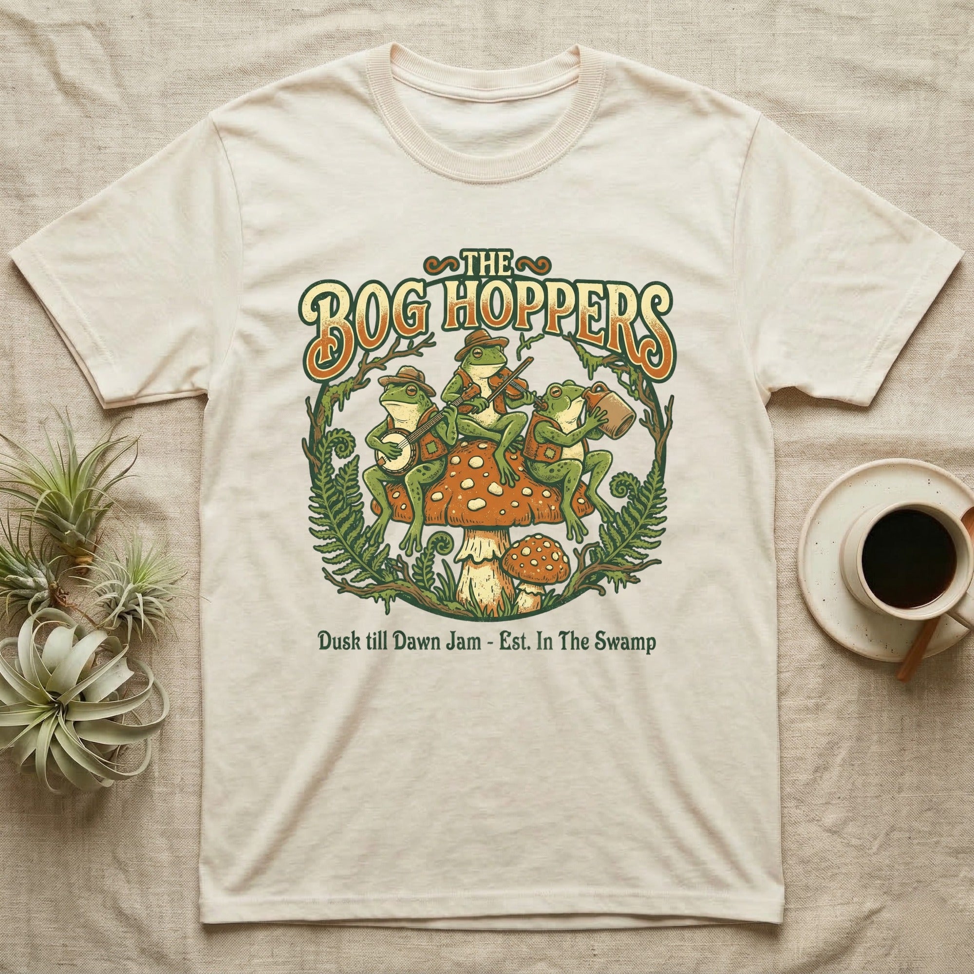 The Bog Hoppers band logo with frogs playing instruments on a mushroom.