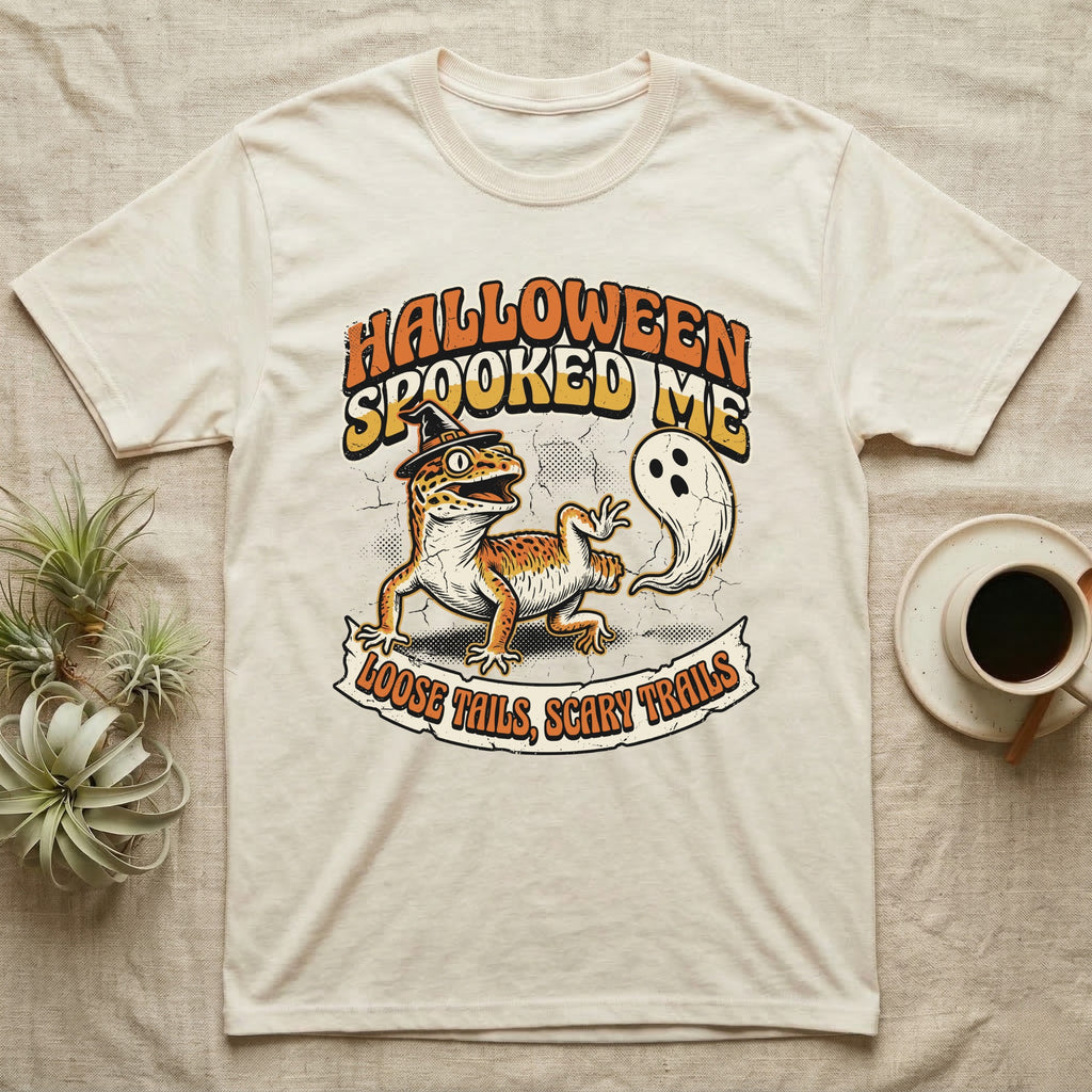 Leopard Gecko Spooked Me T-Shirt in Natural — Distressed graphic of a shocked leopard gecko in a witch hat beside its ghost-costumed dropped tail, "Halloween Spooked Me."