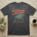 Desert Rain Frog Grump Mode T-Shirt in Dark Heather — Illustrated desert rain frog lounging in a beach chair with sunglasses and a cocktail, coral script reading Perpetually Miserable But Relaxed.